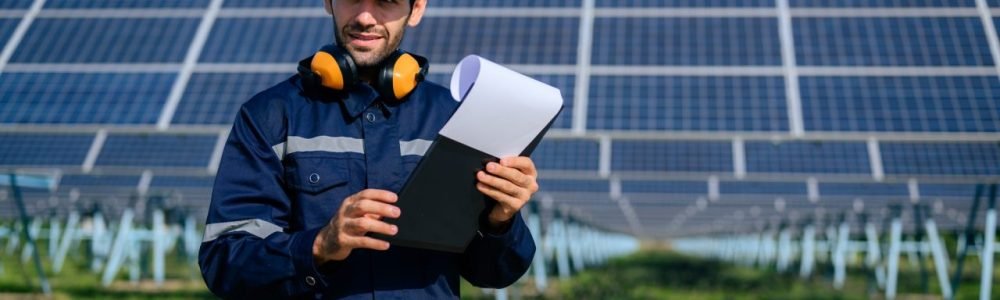 engineer-worker-portrait-with-solar-panel-at-solar-farm.jpg